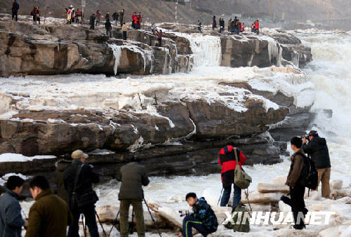 1月2日，几名摄影爱好者在黄河壶口瀑布景区拍照。