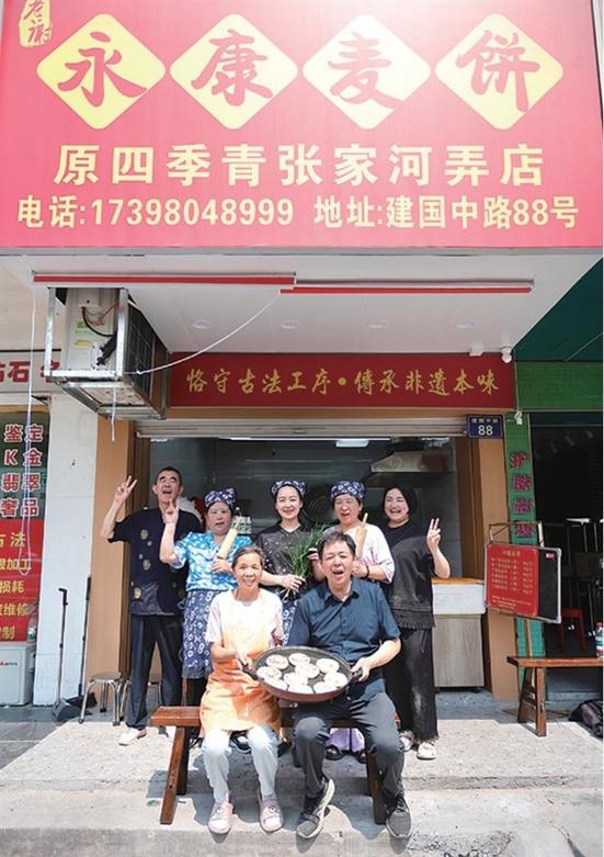 李阿姨、老谢(第一排)与接班人娜娜(后排左三)、佳佳(后排左五)等人的合影 记者 江玥 摄