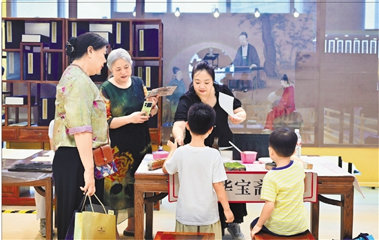 在书博会现场,读者在“宋韵书香”书院体验竹纸古法制作、雕版印刷。 本报记者 董旭明 林云龙 摄