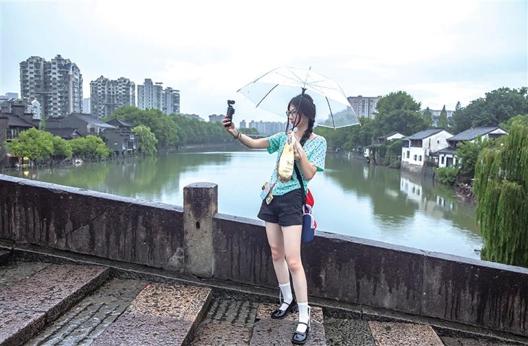 昨天傍晚,游客在雨中“打卡”拱宸桥。 记者 陈中秋 摄